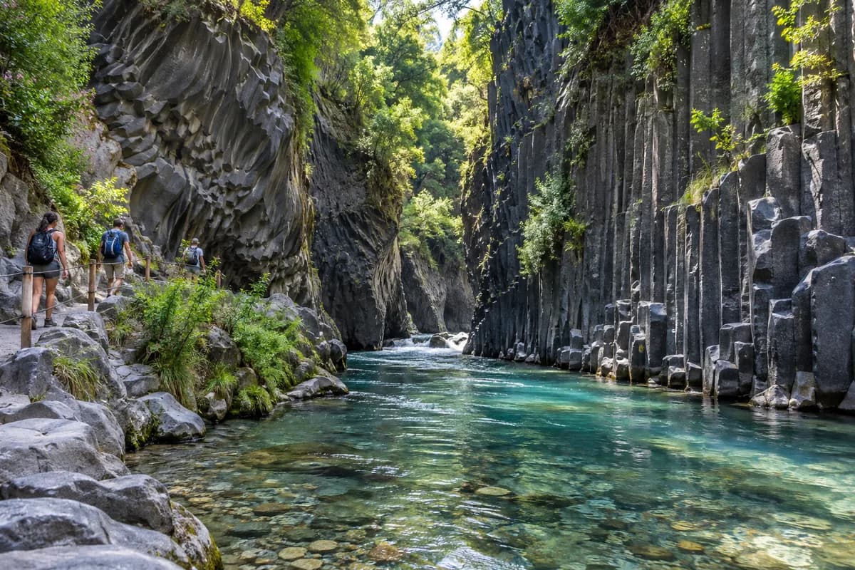 Gole dell'Alcantara con pareti di basalto, acqua limpida e visitatori sul sentiero, immagine illustrativa
