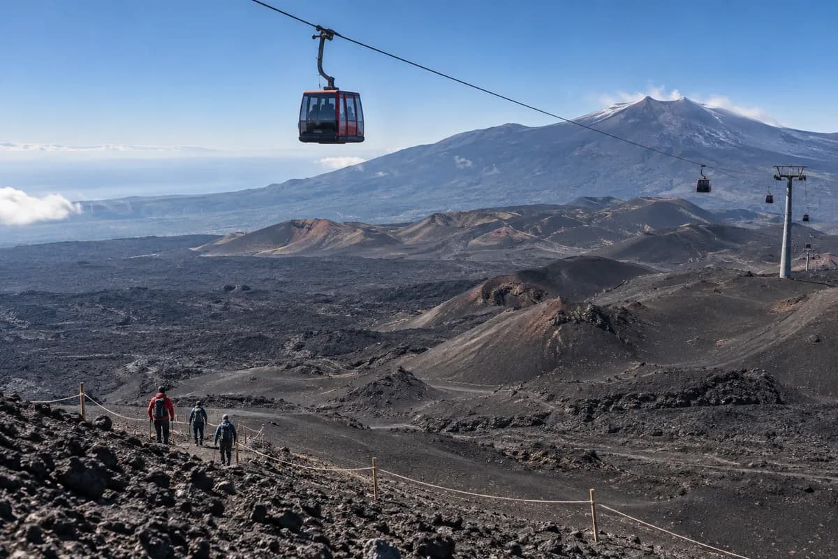 Funivia e persone equipaggiate nel paesaggio vulcanico d'alta quota dell'Etna, immagine illustrativa
